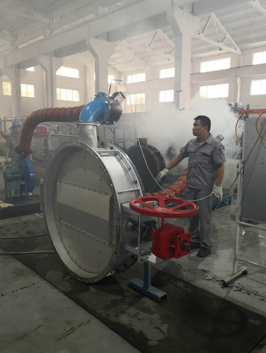 A workshop smoke leakage test verifies the sealing performance of an industrial butterfly damper.