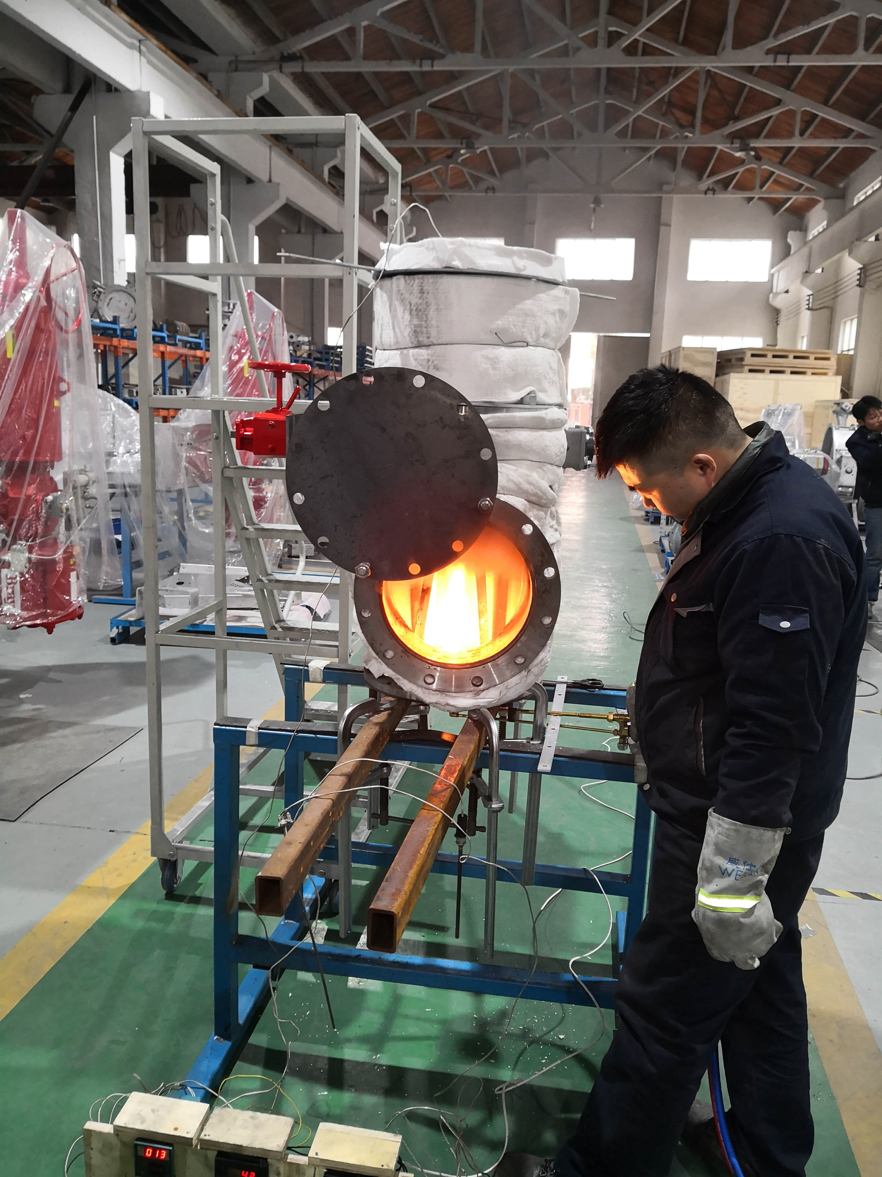 A high-temperature industrial damper is tested for thermal expansion performance on a workshop test bench.
