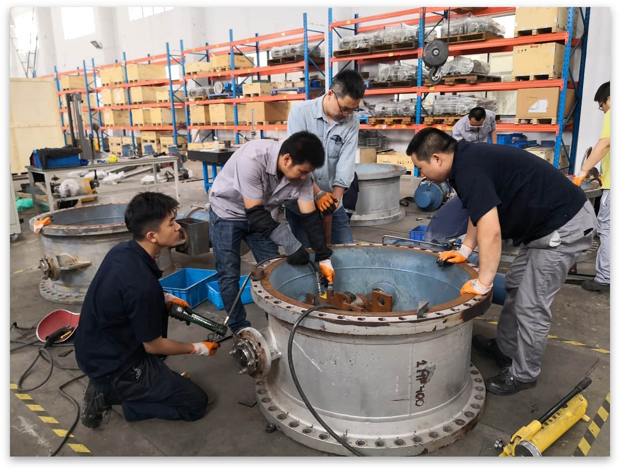 Technicians refurbish and upgrade a large-diameter flue butterfly damper.